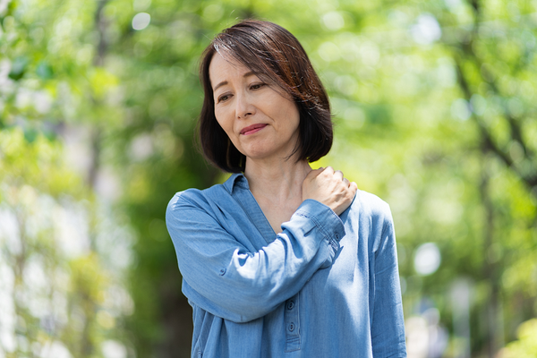 肩の痛みを感じる女性